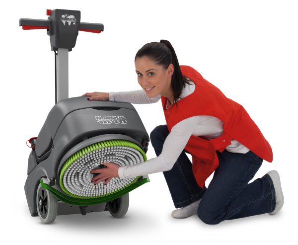 Woman fixing a green and white scrubbing brush onto a scrubber dryer model TTB1840NX