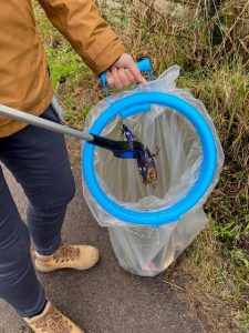 litter going into a sack through a bag hoop